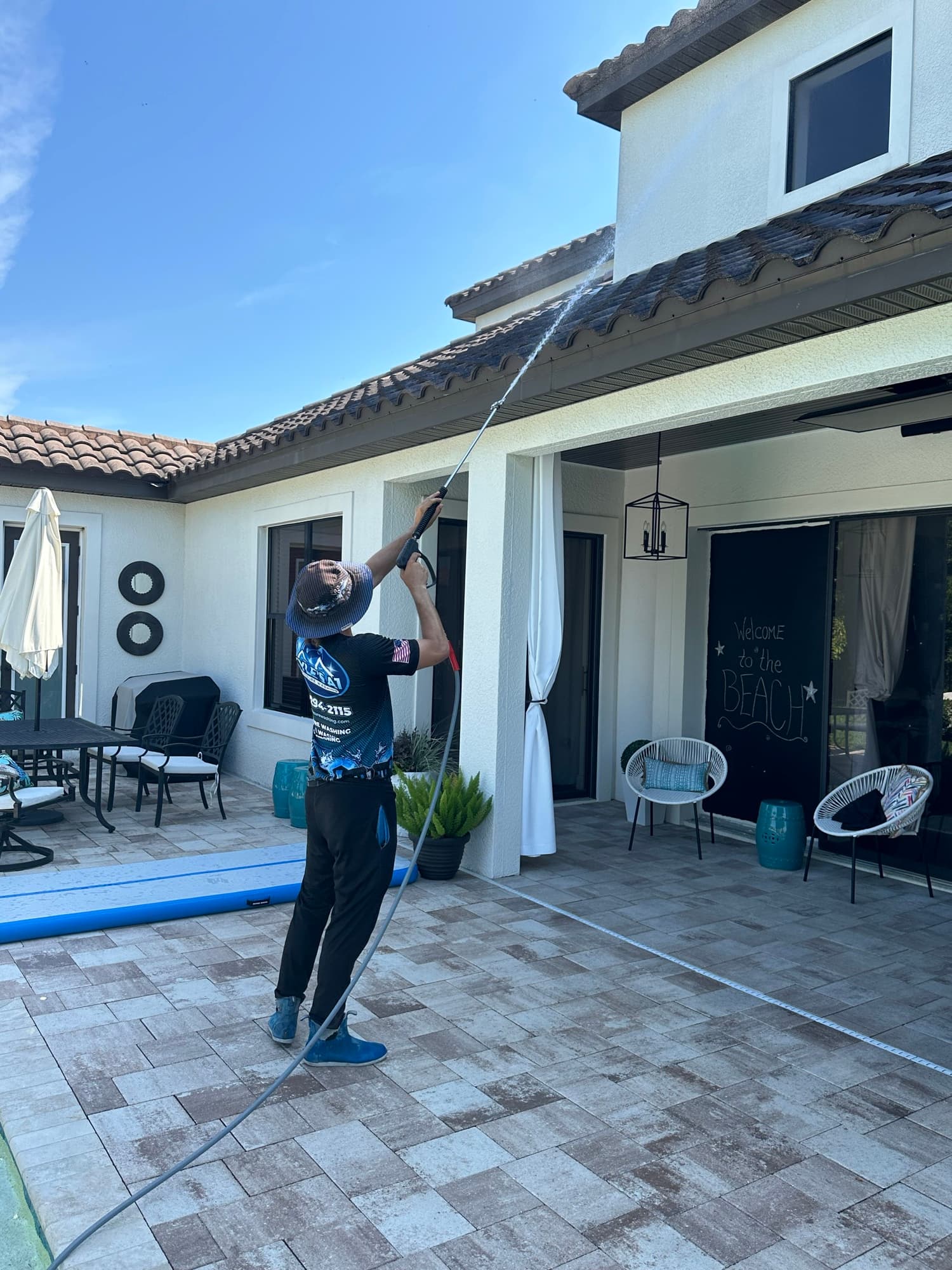 Technician soft washing house exterior