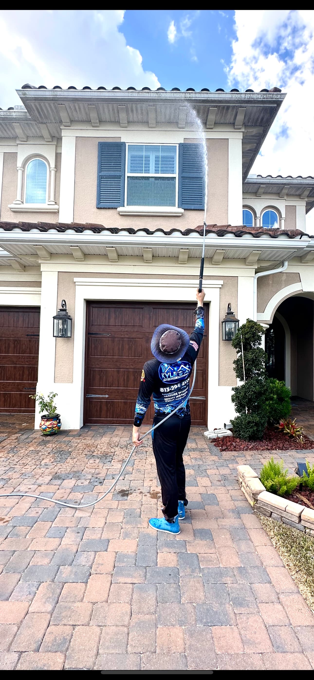 Technician washing luxury home exterior in Dover