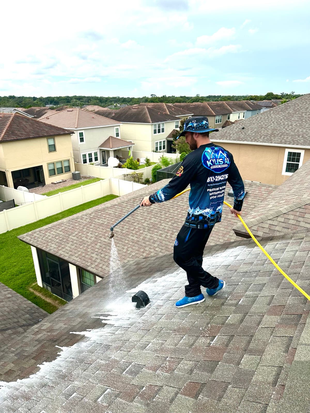 Technician pressure washing roof